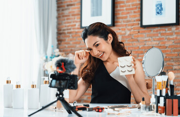 Woman influencer shoot live streaming vlog video review makeup uttermost social media or blog. Happy young girl with cosmetics studio lighting for marketing recording session broadcasting online. - obrazy, fototapety, plakaty