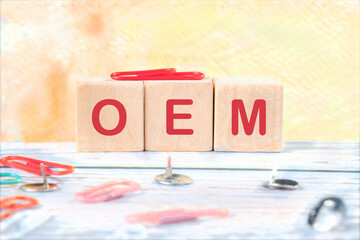 Acronym concept. OEM Original Equipment Manufacturerit is written on wooden cubes on a colored background