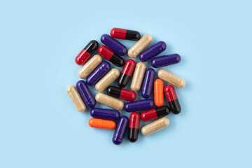Heap of colorful medicine pills on blue background