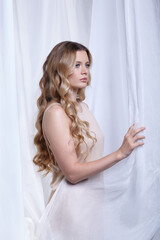 Portrait of a young woman against a background of white fabric. Female beauty concept. - 786084287