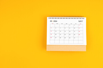 May 2024 desk calendar on yellow color background, position with copy space.