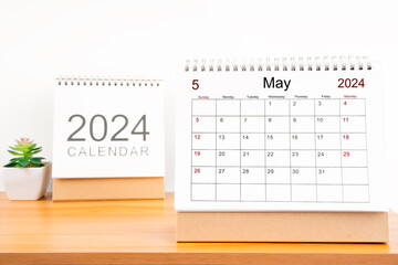 Monthly desk calendar May 2024 year on wooden table.
