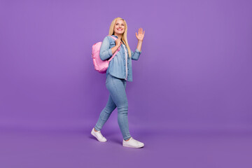 Full length body size view of nice cheery girl going back to school waving greetings isolated over...