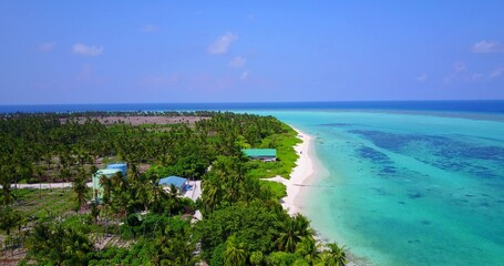 Aerial view of a beautiful tropical island with a sandy beach and a clear blue water on a sunny day