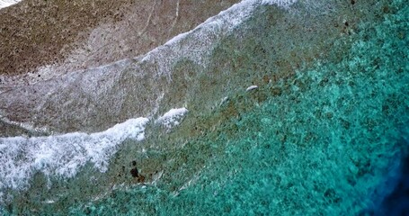 Aerial view of a beautiful island with crystal clear water and calm foamy waves