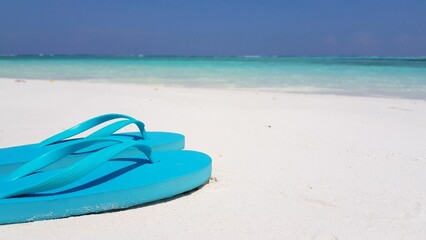 Closeup of flip-flops at a beach on a summer sunny day