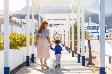 A mother with her son on vacation at Puerto de Las Nieves in Agaete on Gran Canaria, Spain - obrazy, fototapety, plakaty