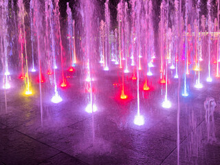 Colorful water fountain dance show with laser light at night.