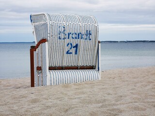 Beach chair on the sand by the sea with the number 21