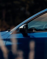 Side shot of a shiny blue sport car mirror with blur background, vertical shot
