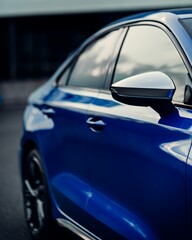 Side shot of a shiny blue sport car mirror and windows with blur background, vertical shot