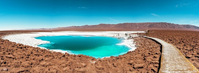 Panoramic view of tourists at an oasis with turquoise water lagoon in the Atacama desert, Chile