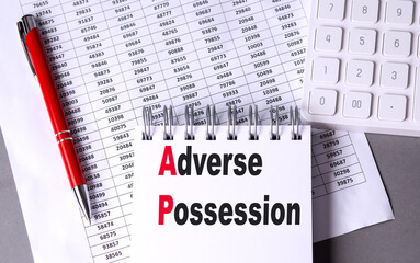 ADVERSE POSSESSION text on notebook with chart , pen and calculator