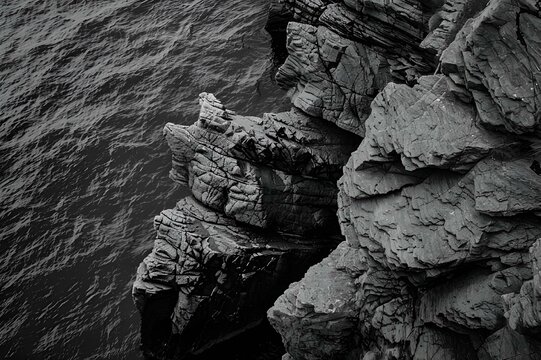 AI generated illustration of a monochrome image of a cliff and the sea