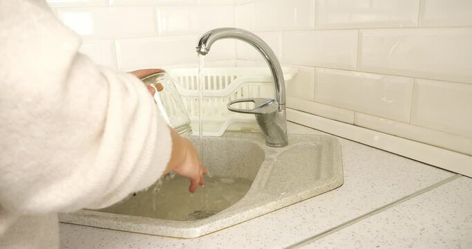 On the farm, a housewife and eco-activist washes glass jars for sorting during recycling. A responsible woman takes care of nature and sorts garbage for recycling.