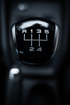 Gear stick knob with leather closeup from top view. Dark black and white manual car interior. Gear lever, gearshift, shifter, transmission lever.	
