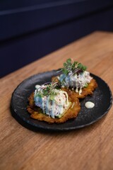 Pieces of crab cake on top of smashed plantain for brunch ideas, vertical shot