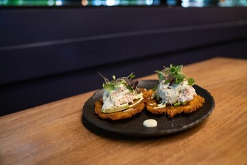 Pieces of crab cake on top of smashed plantain for brunch ideas