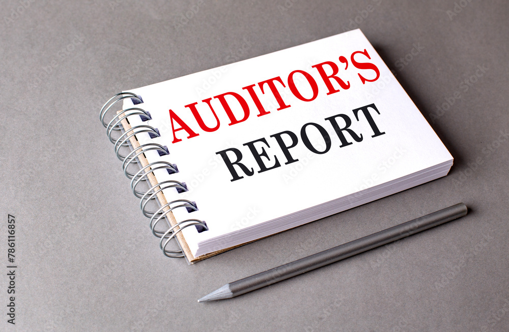 Aufkleber auditor's report text on notebook on grey background