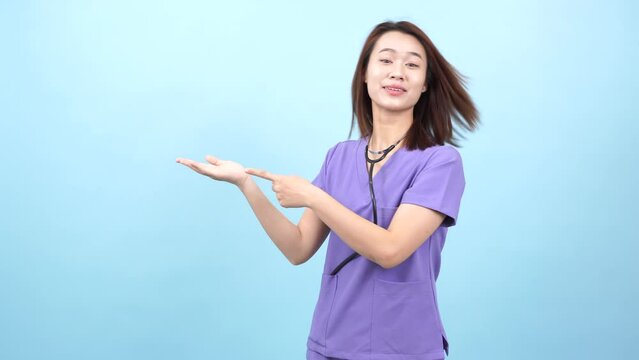 Young Asian female doctor on blue background