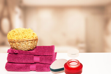 Closeup of fresh soft terry bath towels and soap, shampoo bottles and a basket with a natural...