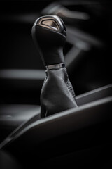 Gear stick with leather closeup from side view. Dark black and white manual car interior. Gear...