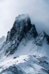 a snowy, rugged mountain peak surrounded by clouds, conveying a serene yet formidable atmosphere