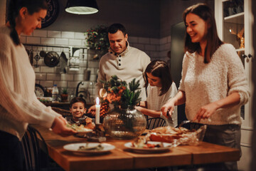 Family preparing traditional festive Christmas Eve dinner together in cozy homely atmosphere, two...