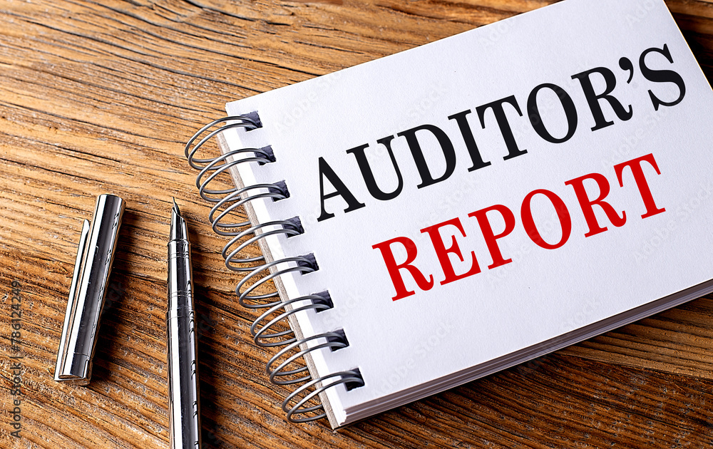 Poster auditor's report text on notebook with pen on the wooden background