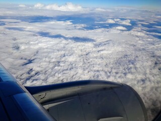 Sicht aus dem Flugzeug-Fenster auf die Wolken und Turbine