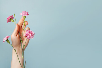 flowers in women's hand, blue background. health concept