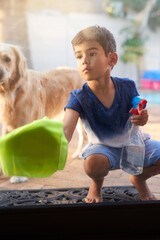 Spray bottle, cloth and child cleaning window to prevent dirt, germs or bacteria with dog at home....