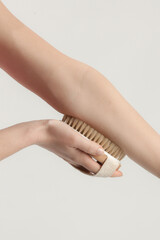Dry body brush, Woman dry brushing body to reduce cellulite, detoxify the lymphatic system, and achieve beautiful smooth skin. Dry skin brushing as part of morning health and energy routine.