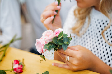 A woman is seated, cradling a bouquet of flowers in her hands