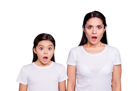 Close up photo pretty two people brown haired mum small little daughter eyes mouth opened frightened oh no facial expression wearing white t-shirts isolated bright blue background