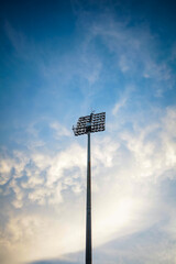 Stadium lights isolated on blue sky and clouds.