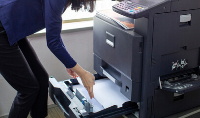a hand was loading a number of A4 size HVS papers for him to print in his office
