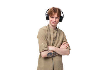 young cute caucasian guy with red hair listens to favorite playlist in headphones