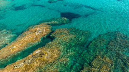 Aerial view on the rocks in the crystal clear sea of southern Sardinia, Italy. The sea is clean with colors ranging from blue to turquoise.