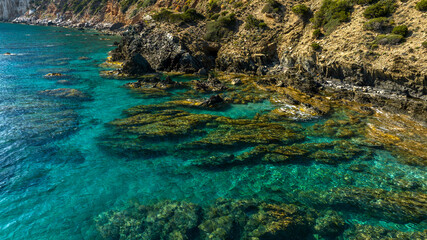 Aerial view on the rocks in the crystal clear sea of southern Sardinia, Italy. The sea is clean with colors ranging from blue to turquoise.