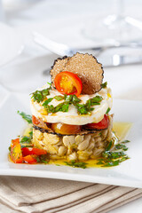 Broad bean vegetable timbale with cheese, cherry tomato and black truffle..