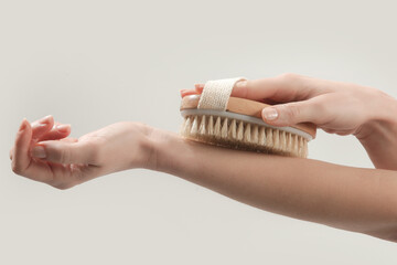 Dry body brush, Woman dry brushing body to reduce cellulite, detoxify the lymphatic system, and achieve beautiful smooth skin. Dry skin brushing as part of morning health and energy routine.
