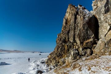Fototapeta na wymiar Lake Baikal in winter. Beautiful rocky island on a background of blue sky and ice.