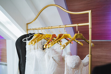 Row of wedding dresses on clothes hangers in magenta room