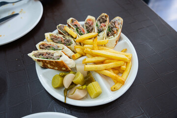 delicious chopped shawarma with french fries and pickled radish, cucumber and green chili