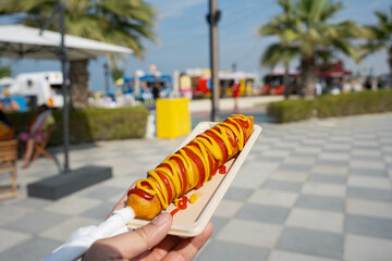 Arabian corn dog with mustard and ketchup on a sunny day