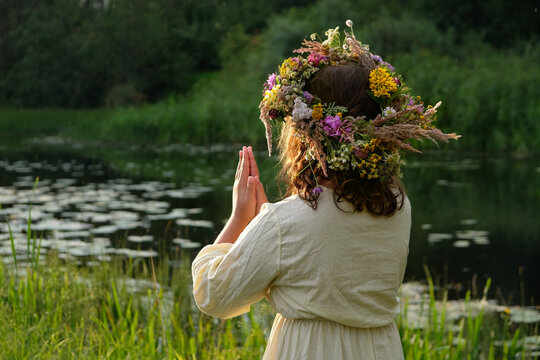 girl in flower wreath outdoor, natural background. Floral crown, symbol of summer solstice. ceremony for Midsummer, wiccan Litha sabbat. pagan folk holiday Ivan Kupala. Magic ritual. witchcraft
