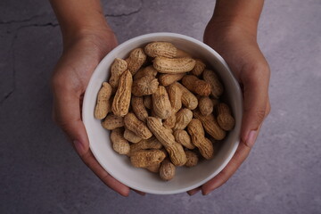 a bowl of peanuts in a hand top view