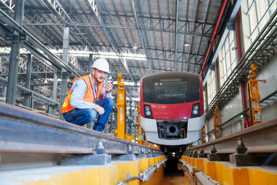 Electrical engineer railway in the maintenance station checking process of sky electric train, public vehicle traffic important infrastructure in Thailand. using walkie-talkie in work. transportation,
