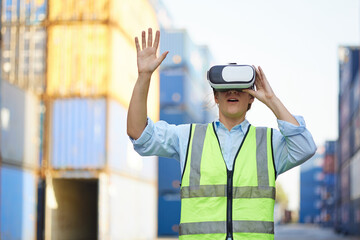 worker or engineer wearing virtual reality glasses(VR) in containers warehouse storage